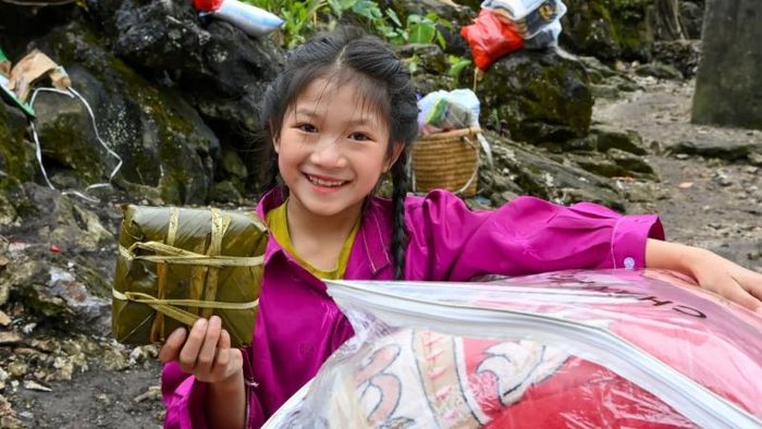 Bé gái người Dao vui mừng khi được tặng quà và bánh trưng.