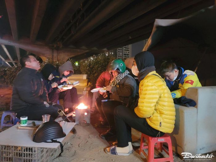 Mọi người tranh thủ vừa ăn khuya vừa sưởi ấm trước khi tiếp tục công việc trong đêm khuya giá rét.