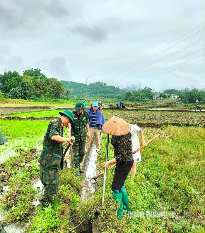 Người dân thôn 10 được bộ đội hỗ trợ lắp đặt cấu kiện kênh mương nội đồng.