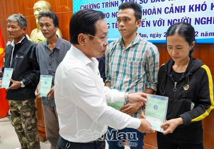 Ông Trịnh Trung Kiên, Giám đốc BHXH tỉnh Cà Mau, trao tặng sổ BHXH cho người dân có hoàn cảnh khó khăn.