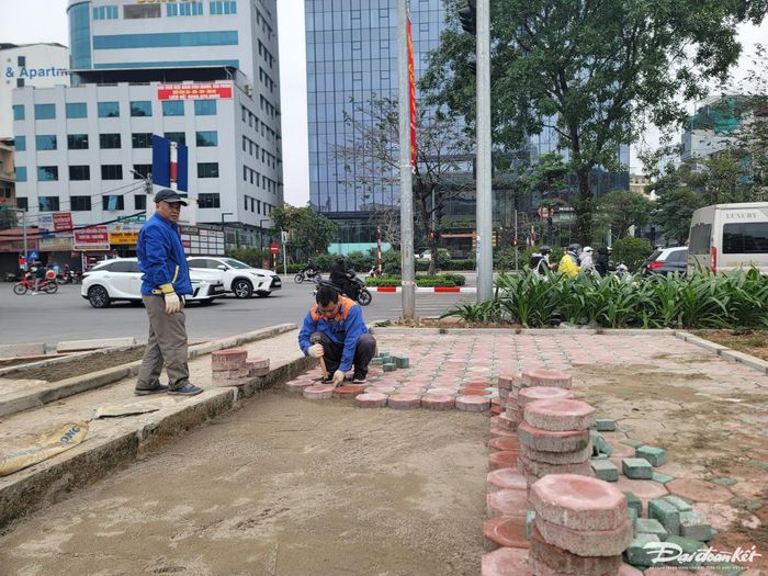 Công nhân Công ty Cổ phần Công trình Giao thông Hà Nội đang hoàn thiện lát đá tại vị trí trạm xe đạp công cộng.