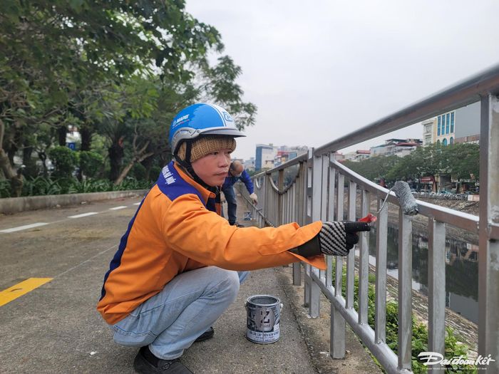 Công nhân đang sơn lan can đường.