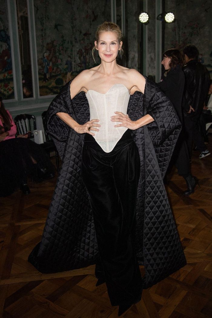 Không diện corset bên trong như Kim Kardashian, Kelly Rutherford thoải mái mặc item này ở phía ngoài, hưởng ứng trào lưu khoe trang phục lót. Thiết kế corset với đường gân cố định này trước đó cũng được ca sĩ Rita Ora diện khi tham dự Liên hoan phim Venice 2023. Trong khi Kelly Rutherford xây dựng concept trang trọng, quyến rũ phù hợp với tinh thần của thời trang may đo cao cấp, Rita Ora lại mang đến nét cá tính cho outfit sử dụng chiếc corset trắng. Ảnh: HawtCelebs, Celeb Mafia.