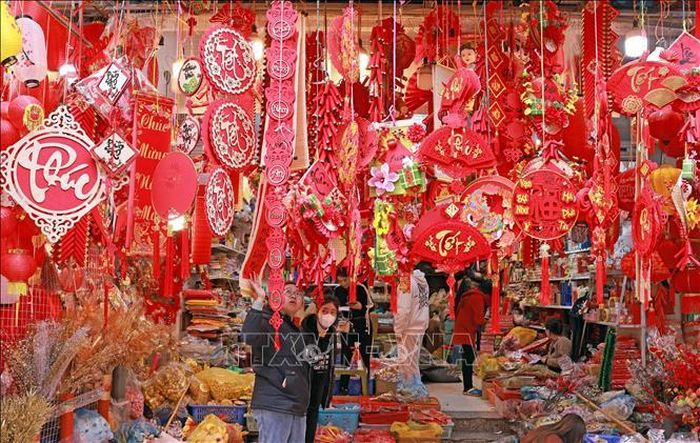 Khách lựa chọn, mua sắm đồ trang trí Tết tại phố Hàng Mã.