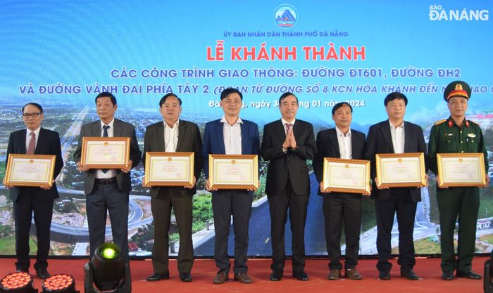 Chủ tịch UBND thành phố Lê Trung Chinh tặng Bằng khen cho 7 tập thể có thành tích xuất sắc trong công tác quản lý đầu tư, đền bù giải tỏa và triển khai 3 công trình giao thông. Ảnh: HOÀNG HIỆP