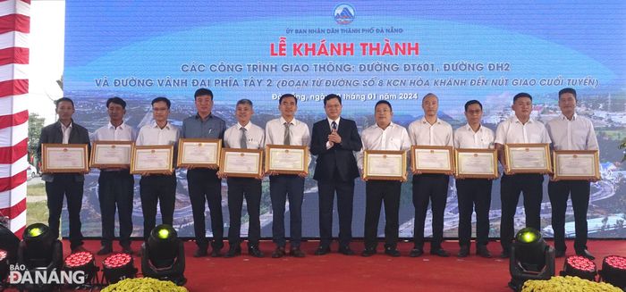 Phó Chủ tịch Thường trực HĐND thành phố Trần Phước Sơn trao Bằng khen của Chủ tịch UBND thành phố cho các cá nhân có thành tích xuất sắc trong công tác quản lý đầu tư, đền bù giải tỏa và triển khai 3 công trình giao thông. Ảnh: HOÀNG HIỆP
