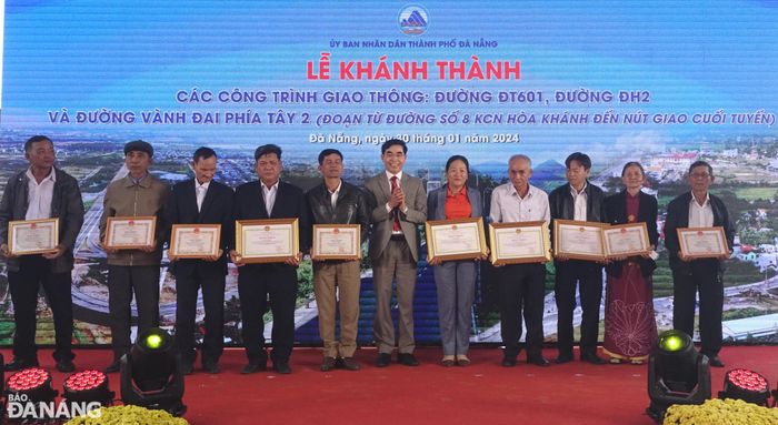 Chủ tịch UBND huyện Hòa Vang Phan Văn Tôn tặng Bằng khen của Chủ tịch UBND thành phố và Giấy khen của huyện cho các trưởng thôn và hộ giải tỏa có thành tích xuất sắc trong công tác giải phóng mặt bằng các công trình giao thông. Ảnh: HOÀNG HIỆP