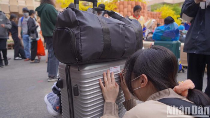 Các sinh viên ghi lại tên trên hành lý của mình.