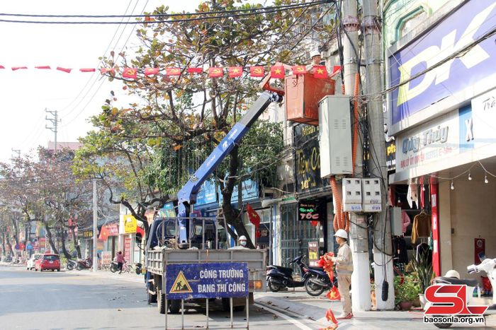 Công nhân Công ty cổ phần Môi trường và Dịch vụ đô thị Sơn La lắp đặt cờ, băng rôn các tuyến đường.