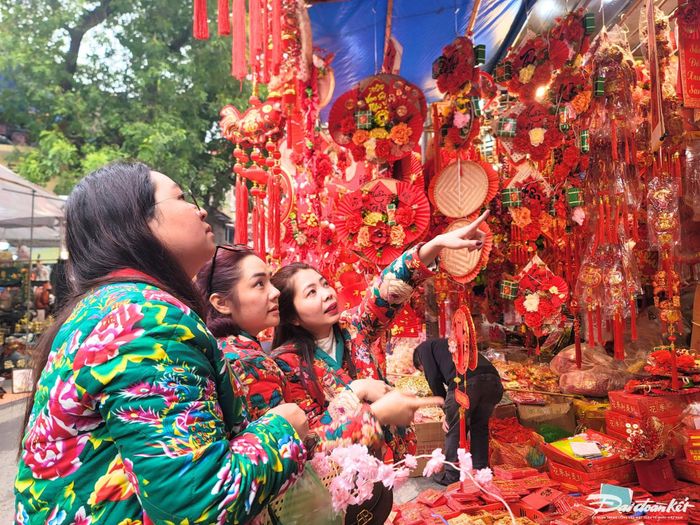 Chị Yến Linh (36 tuổi, ở Hai Bà Trưng, Hà Nội) đang cùng 2 người bạn chọn món đồ trang trí Tết ưng ý cho gia đình. "Trước Tết năm nào tôi cũng đến đây, vừa mua đồ vừa tranh thủ lưu lại những hình ảnh ở phố Hàng mã", chị chia sẻ.