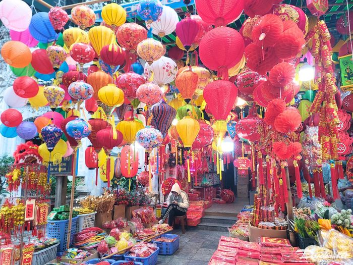 Chạy dọc con phố là sắc màu rực rỡ của đồ trang trí Tết: đèn lồng, pháo, bánh chưng giấy, hoa nhựa,...