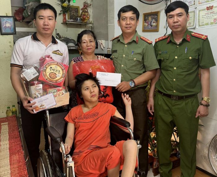 Đại diện Thanh tra Công an TP Đà Nẵng và các nhà hảo tâm tặng quà Tết cho gia đình cháu Uyên.