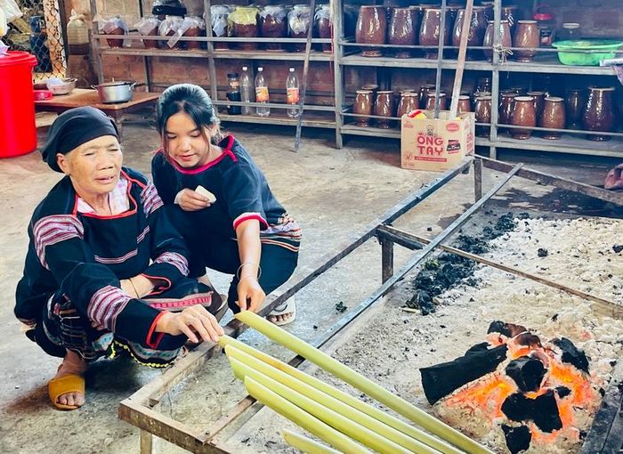 Bà H’Nut chỉ dạy bí quyết chế biến món ăn truyền thống của người Jrai cho thế hệ trẻ trong làng. Ảnh: Mai Ka
