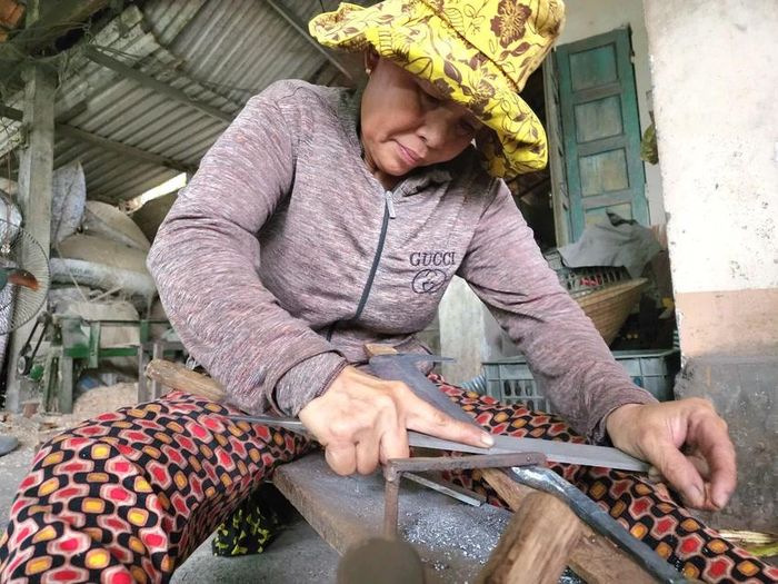  Người dân làng rèn mài cho nông cụ thêm sắc bén. Ảnh: MINH TRƯỜNG. 