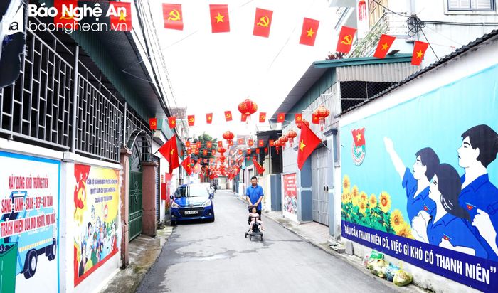  Đoạn đường Trường Tiến ở khối Trường Tiến, phường Hưng Bình (TP. Vinh) được 13 hộ góp tiền, ngày công trang trí cờ và in nhiều tranh cổ động phủ kín các bờ tường cũ. Ảnh: Nguyên Nguyên 