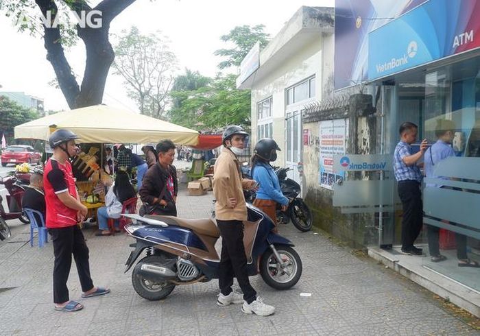 Người dân chờ rút tiền cây ATM của Ngân hàng TMCP Công thương Việt Nam (Vietinbank) sáng 7-2 tại gần Trường Đại học Sư phạm (Đại học Đà Nẵng), quận Liên Chiểu. Ảnh: M.Q