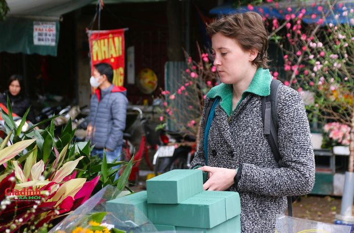 Khách du lịch nước ngoài tranh thủ dạo chơi, mua hoa tại chợ hoa Quảng An.