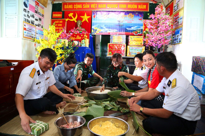 Quân dân chung vui gói bánh chưng xanh. 
