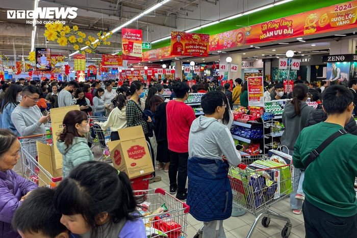 Khách xếp hàng dài chờ đợi trả tiền, còn nhân viên các quầy thanh toán làm việc hết công suất, không kịp ngơi tay. Hầu hết đều phải tăng ca trong dịp bán hàng Tết.