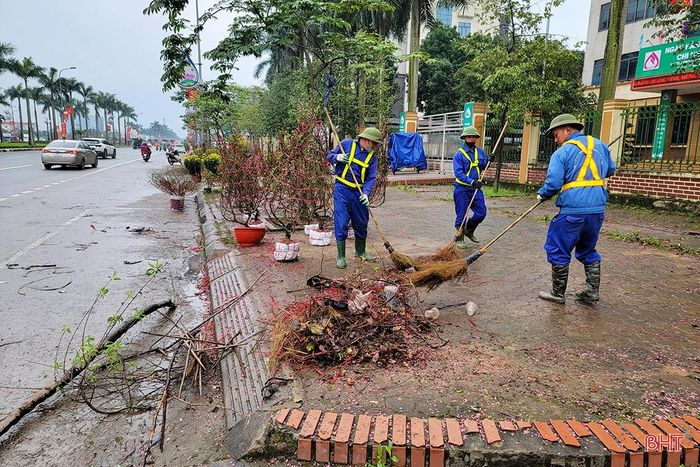 Tiêu thụ chậm khiến một số tiểu thương, nhất là những người buôn bán đào, mai thế đã chủ động thu dọn hàng, sớm hoàn trả mặt bằng trước giờ quy định - 17h30' chiều 30 tết. Trong ảnh: Công nhân môi trường thu dọn các khu vực bán cây cảnh ở đường Xô Viết Nghệ Tĩnh.