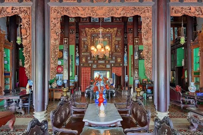 Giữa nhà là gian thờ lớn theo kiểu truyền thống của người Nam Bộ. Đồ thờ đều được trạm trổ tinh tế với những hình ảnh mang tính biểu tượng trong văn hóa phương Đông như trúc, cúc, mai, công, rồng, phượng... Ảnh: Canthotourism