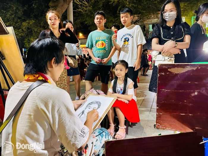 Một bé gái đang được họa sĩ đường phố vẽ chân dung thời điểm giao thời giữa năm cũ và năm mới