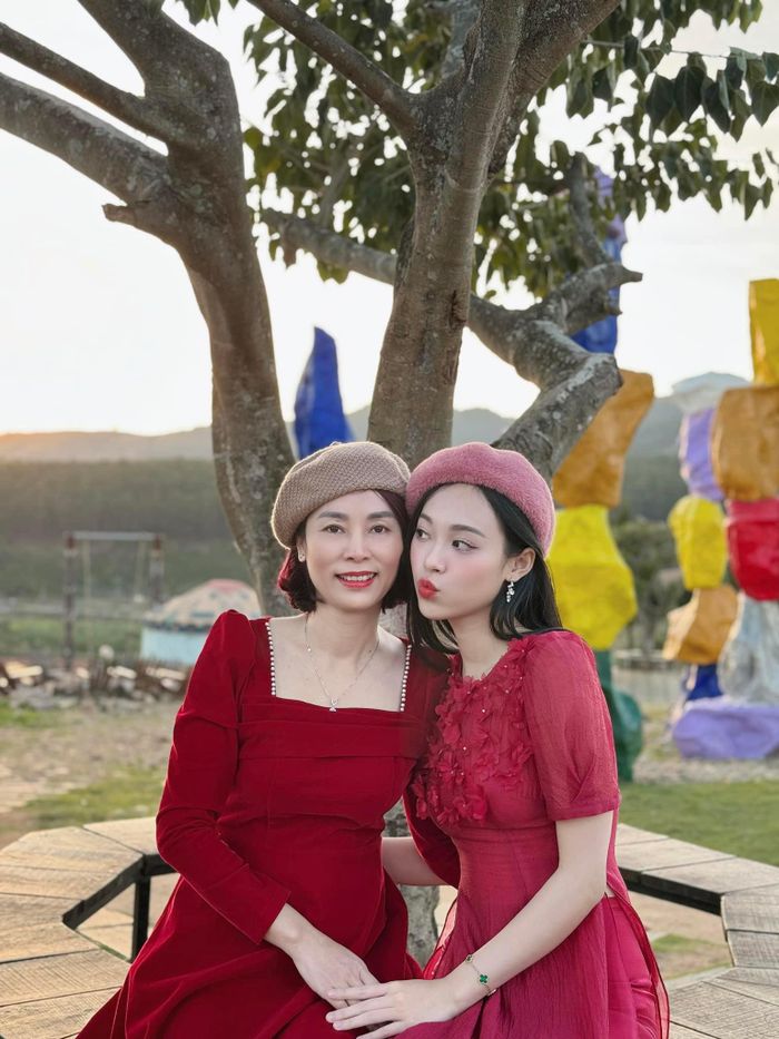 Á hậu Trịnh Thùy Linh và mẹ mặc áo dài đôi tông màu đỏ trong ngày Tết.