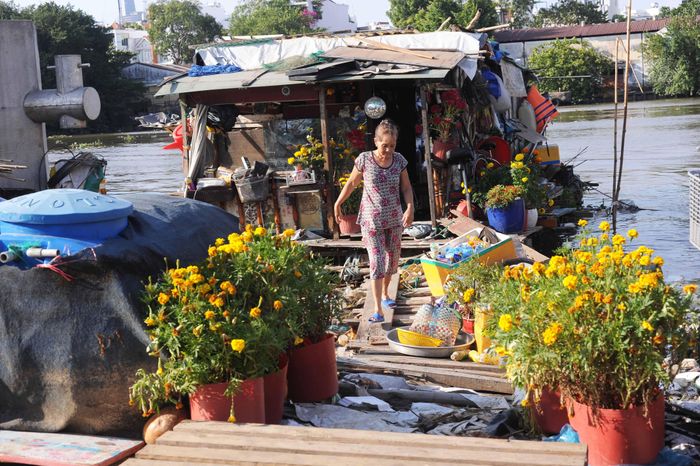 Tuy nhiên, xóm vẫn có vài gia đình ở lại đón Tết. Bà Phan Thị Màu cho biết: "Tôi nhặt đám hoa người ta bỏ đi để trang trí thuyền hoa ăn Tết".
