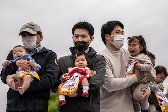 Cha mẹ cho các con nhỏ tham gia một trò chơi ở Tokyo, Nhật Bản. (Ảnh: AFP/TTXVN)