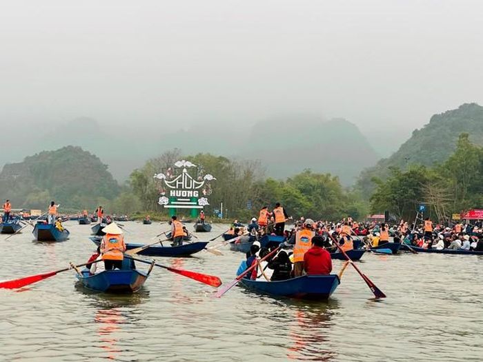 Du khách đi đò vào dự lễ khai hội.