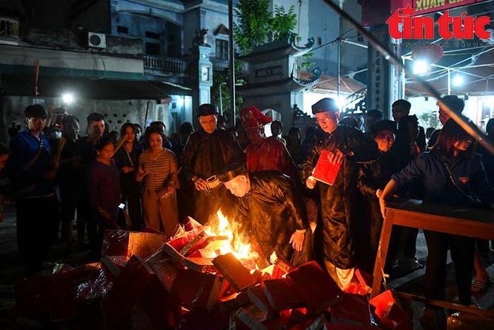 Đúng 20 giờ 30 phút, một vị cao niên vào hậu cung lấy lửa trong điện thờ ra tiến hành "tán lộc" cho dân làng.
