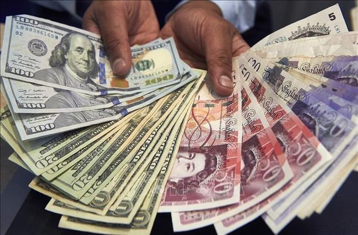 Đồng bảng Anh (phải) và đồng USD. Ảnh: AFP/ TTXVN