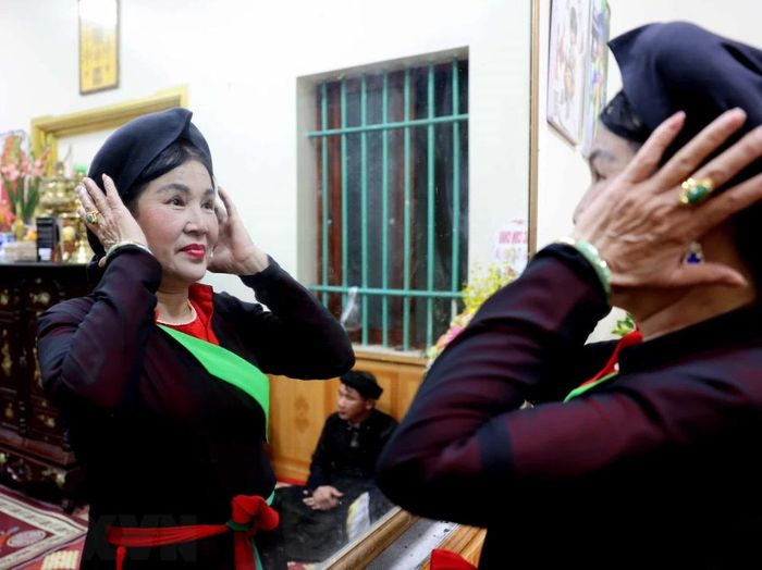  Chị hai vấn lại chiếc khăn mỏ quạ để chuẩn bị vào canh hát. (Ảnh: Nhật Anh/TTXVN) 