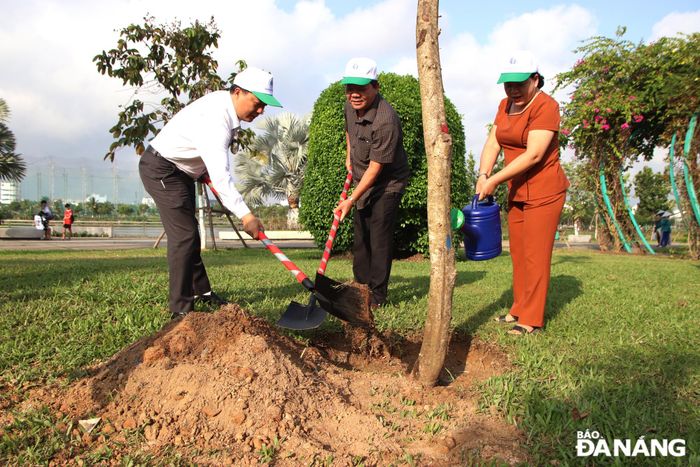 Chủ tịch UBND quận Hải Châu Lê Tự Gia Thạnh (ngoài cùng bên trái) tham gia T trồng cây. Ảnh: TRỌNG HUY