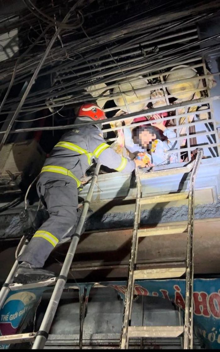 Lực lượng chức năng kịp thời cắt rào sắt, giải cứu 3 người trong vụ cháy.