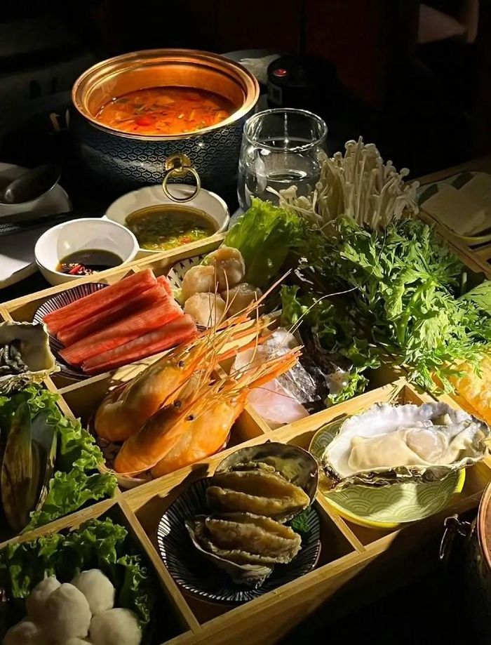 Trước khi chiếu phim, nhân viên sẽ sắp xếp nguyên liệu món lẩu lên bàn theo yêu cầu đặt trước. Khi tới nơi, khách hàng chỉ cần bật công tắc để tự phục vụ. Khi phim bắt đầu chiếu, đèn trong rạp mờ đi, nhưng mỗi bàn đều lắp hai chiếc đèn ngủ nhỏ, để đảm bảo khách hàng vẫn nhìn thấy đồ ăn và nồi lẩu mà không ảnh hưởng đến trải nghiệm xem phim. Ảnh: Weibo.