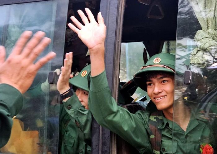  Các tân binh vui mừng chào người thân, bạn bè lên đường đến đơn vị nhận nhiệm vụ. (Ảnh: Trịnh Bang Nhiệm/TTXVN) 