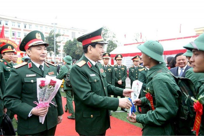 Đại tướng Lương Cường - Ủy viên Bộ Chính trị, Ủy viên Thường vụ Quân ủy Trung ương, Chủ nhiệm Tổng cục Chính trị Quân đội Nhân dân Việt Nam tặng hoa tân binh