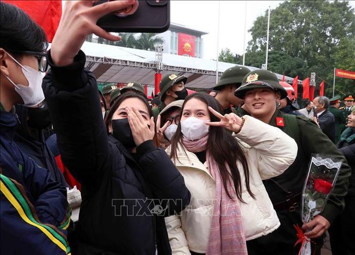Tân binh cùng người thân lưu lại khoảnh khắc đáng nhớ tại điểm giao, nhận quân của quận Long Biên. Ảnh: An Đăng/TTXVN