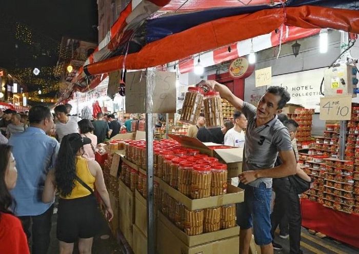 Các chủ gian hàng cố bán hết bánh mứt Tết trước khi Hội Chợ Phố Người Hoa kết thúc. Ảnh: The Straits Times.