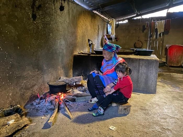 Bà Tráng Thị Chúa và cháu nội bên bếp lửa ở căn nhà cũ