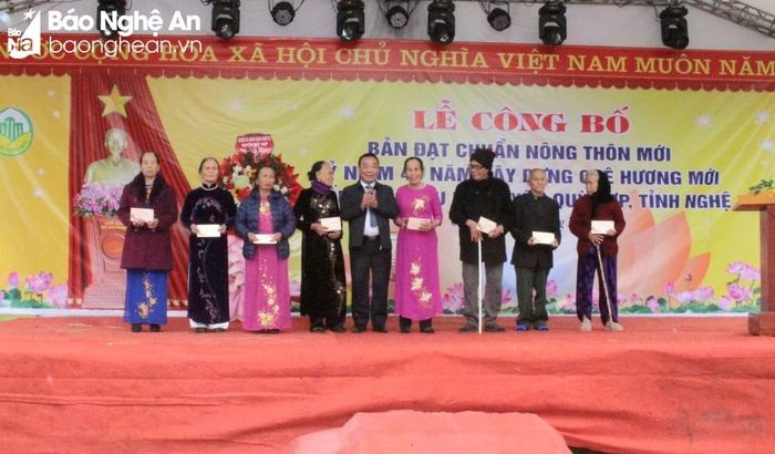 Phó Chủ tịch UBND tỉnh Nguyễn Văn Đệ tặng hoa, quà chúc mừng cán bộ, nhân dân bản Lấu được công nhận đạt chuẩn nông thôn mới. Ảnh: Phan Giang 