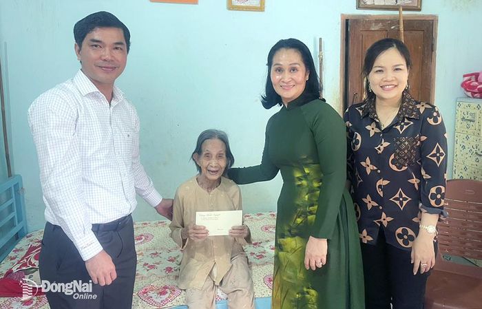 Ủy viên Ban Thường vụ Tỉnh ủy, Bí thư Thành ủy Long Khánh Đặng Minh Nguyệt (thứ 2 từ phải sang) đến thăm và tặng quà cụ Trịnh Thị Khơng