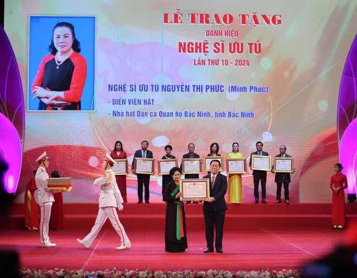 Trưởng Ban Tuyên giáo Trung ương Nguyễn Trọng Nghĩa tặng danh hiệu “Nghệ sĩ ưu tú” cho các nghệ sĩ. Ảnh: Thanh Tùng– TTXVN