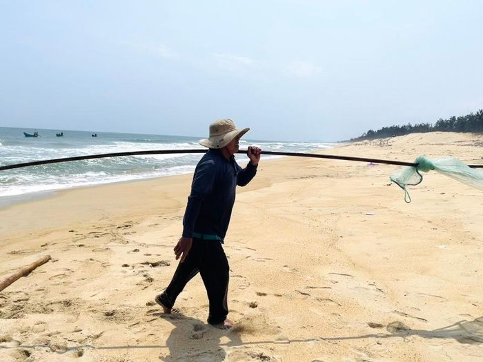 Dụng cụ cào ốc là cây sào sắt dài chừng 8m, nặng 30kg, một đầu gắn vợt. Ảnh: Hà Phương