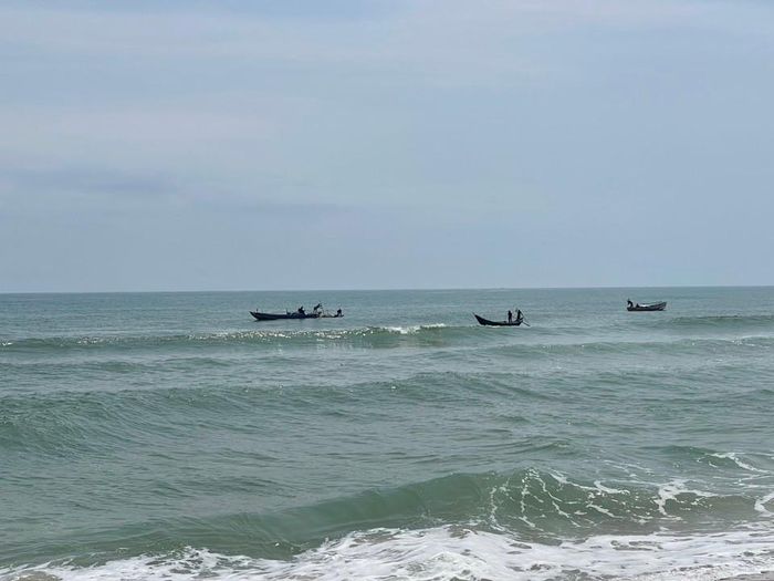 Vào sáng sớm, ngư dân mang dụng cụ, chạy thuyền máy ra cách bờ biển 3 - 5 km để cào ốc. Ảnh: Hà Phương