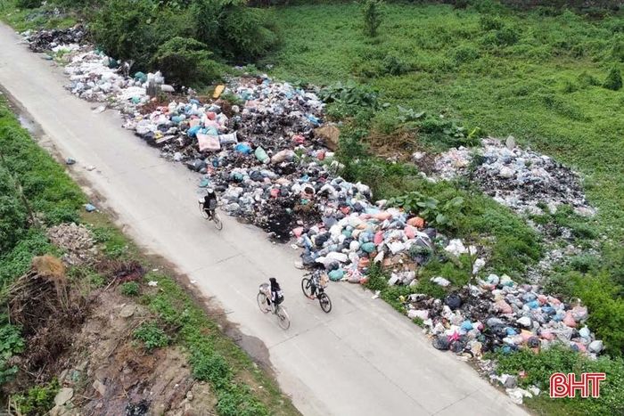  Nằm ngay đối diện là điểm tập kết rác của xã Liên Minh, với lượng rác thải ùn ứ lớn. Điểm tập kết này đã tràn rác thải ra phía ngoài khu vực đường đi lại. 