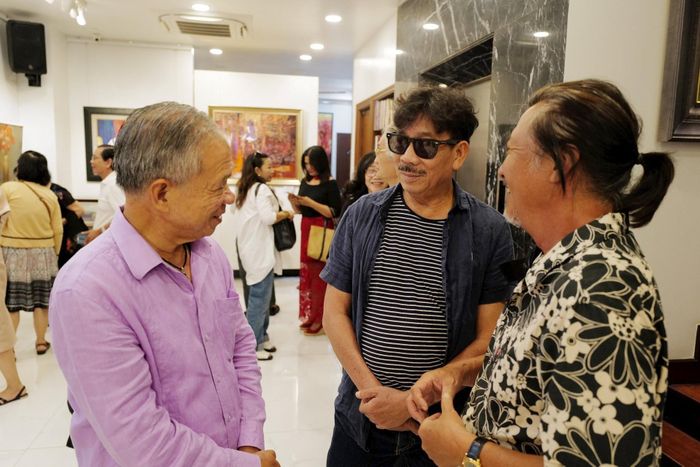 Nhà sưu tập Trương Văn Thuận (bìa trái) tại triển lãm - Ảnh: T.V