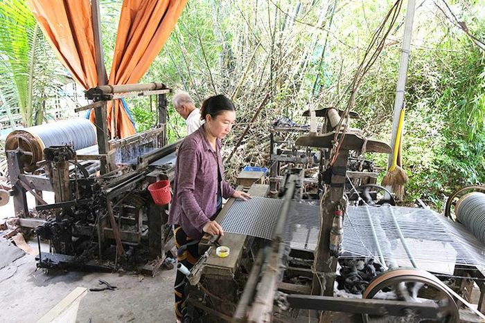 Một hộ dân làng nghề dệt sản phẩm khăn choàng