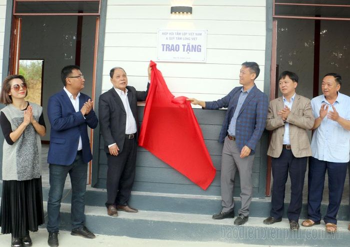 Đại diện nhà tài trợ thực hiện gắn biển công trình Nhà văn hóa bản Huổi Châng.